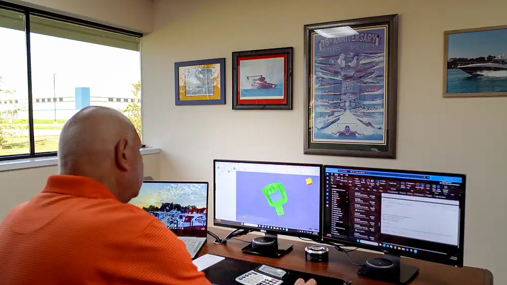 Office workspace with multiple monitors and artwork at BMI-Corp staging site.