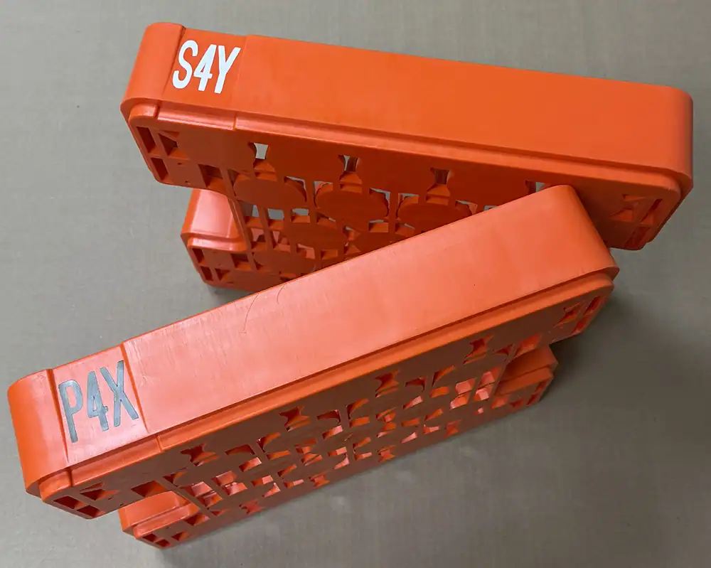 Red stacking storage bins labeled S4Y and PAX for part decorating.